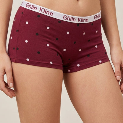 A model wearing burgundy boxer briefs with a white waistband printed with the brand name 'Ghlin Kline' and small black and white polka dots.