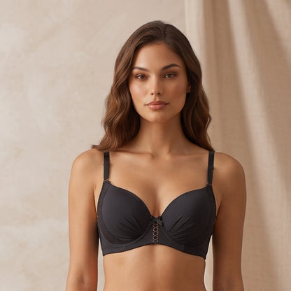 A woman models a two-piece black lingerie set consisting of a bra and high-waisted briefs, standing in a studio with a beige draped backdrop and a black stool. The text 'THE ONYX COLLECTION' is visible in the bottom right corner.