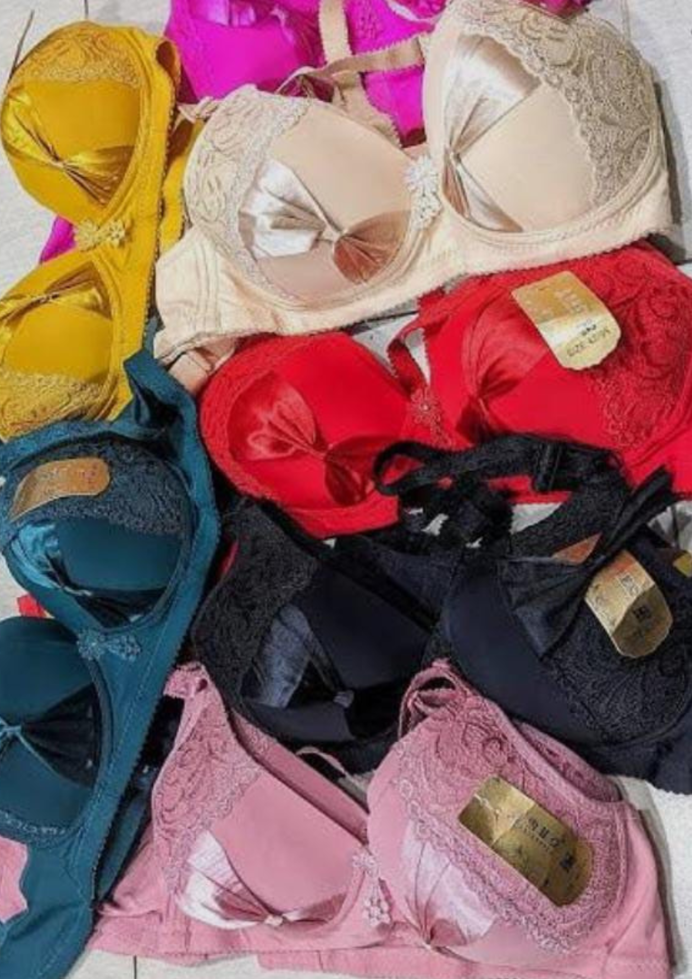 Collection of Inner Bazar lace and satin bras in various colors including red, black, teal, and pink.